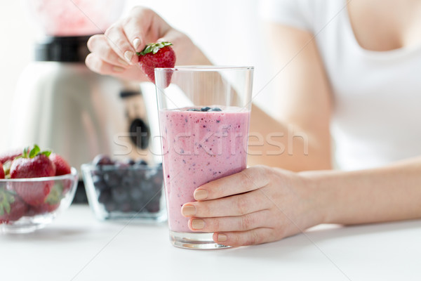 close up of woman with milkshake and strawberry Stock photo © dolgachov