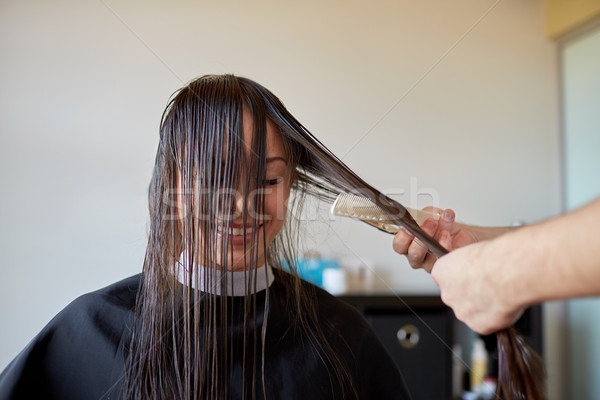 happy woman with stylist cutting hair at salon Stock photo © dolgachov