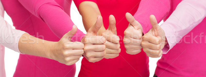 close up of women in pink shirts showing thumbs up Stock photo © dolgachov