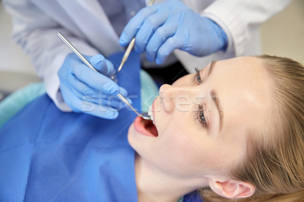 close up of dentist checking female patient teeth Stock photo © dolgachov