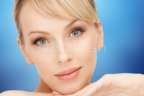 beautiful young woman face over blue background Stock photo © dolgachov