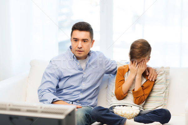 father and son watching horror movie on tv at home Stock photo © dolgachov