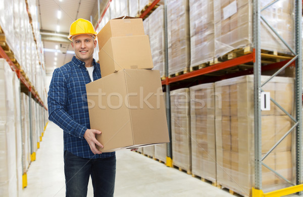 happy man or loader with box at warehouse Stock photo © dolgachov