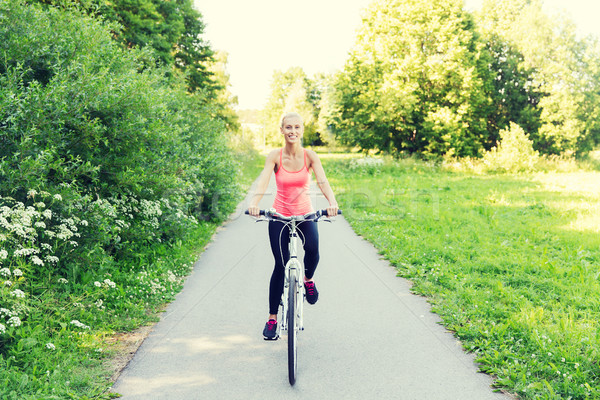 happy young woman riding bicycle outdoors Stock photo © dolgachov