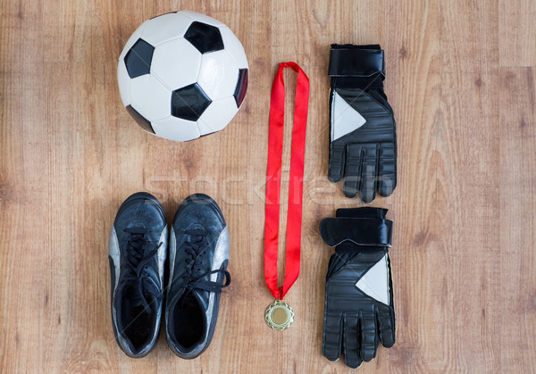 close up of soccer ball, boots, gloves and medal Stock photo © dolgachov