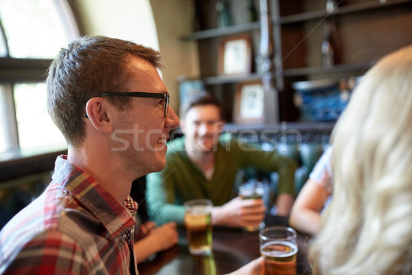 happy man drinking beer with friends at bar or pub Stock photo © dolgachov