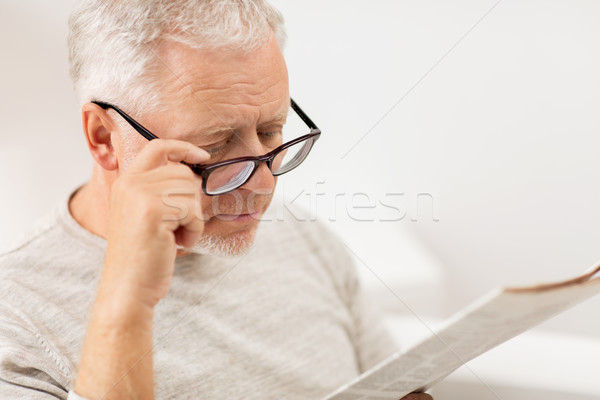 close up of old man in glasses reading newspaper Stock photo © dolgachov