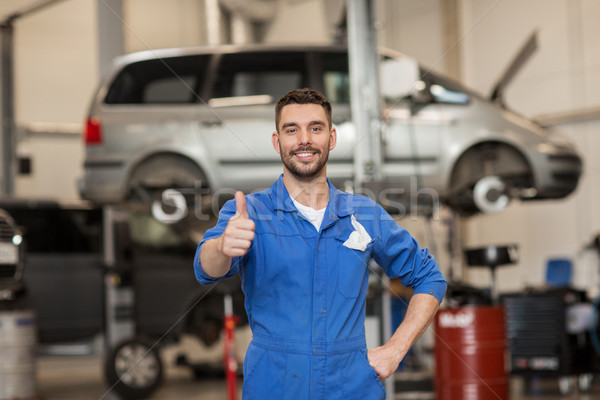 happy auto mechanic man or smith at car workshop Stock photo © dolgachov