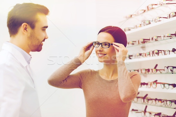 woman choosing glasses at optics store Stock photo © dolgachov