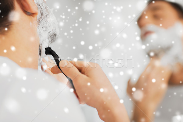 close up of man shaving beard with razor blade Stock photo © dolgachov