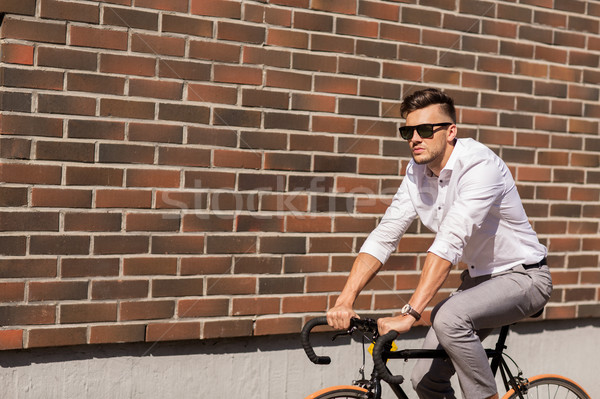 young man riding bicycle on city street Stock photo © dolgachov