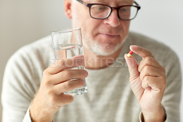 Imagine de stoc: Mâini · medicină · pastile · apă · varsta