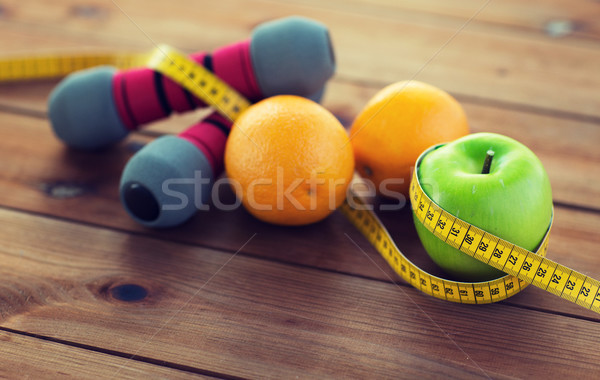 close up of dumbbell, fruits and measuring tape Stock photo © dolgachov