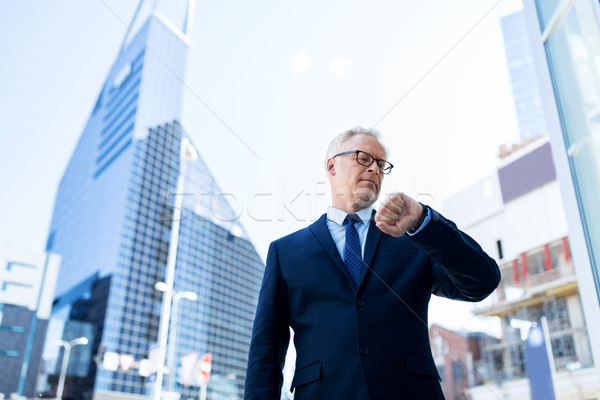 senior businessman checking time on his wristwatch Stock photo © dolgachov