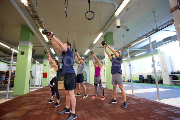 group of people with kettlebells exercising in gym Stock photo © dolgachov