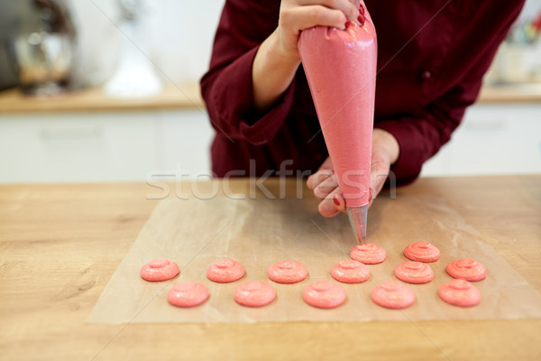 chef with injector squeezing macaron batter Stock photo © dolgachov