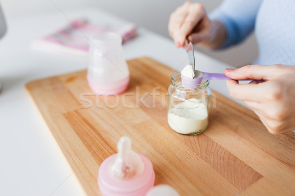 hands with jar and scoop making formula milk Stock photo © dolgachov