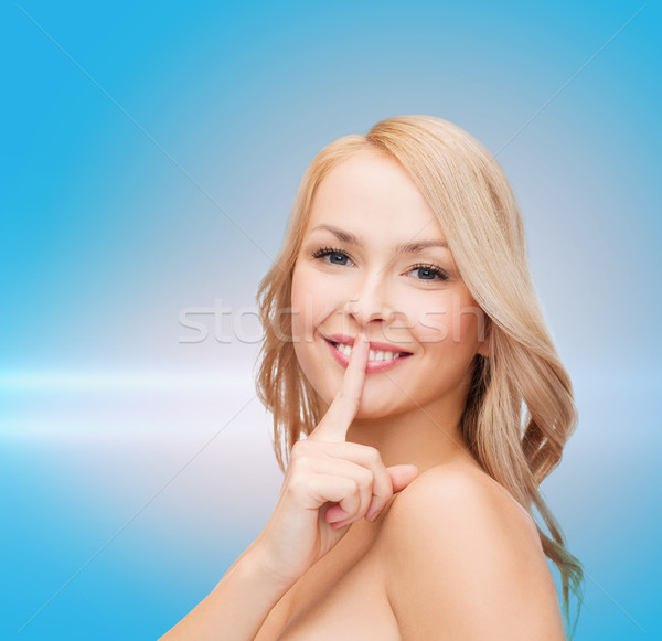 Piękna młoda kobieta wskazując palec usta zdrowia Zdjęcia stock © dolgachov