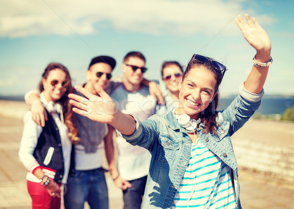 Stock photo: teenage girl with headphones and friends outside