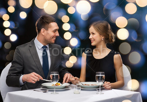 Stock photo: smiling couple eating main course at restaurant