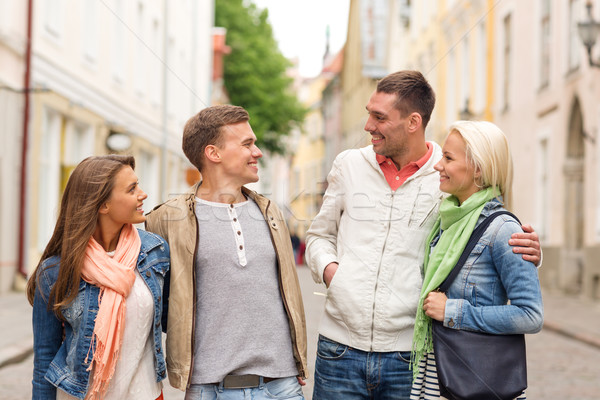 group of smiling friends walking in the city Stock photo © dolgachov