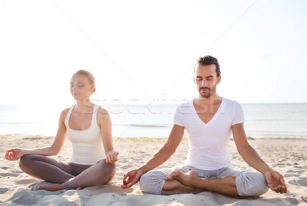 smiling couple making yoga exercises outdoors Stock photo © dolgachov