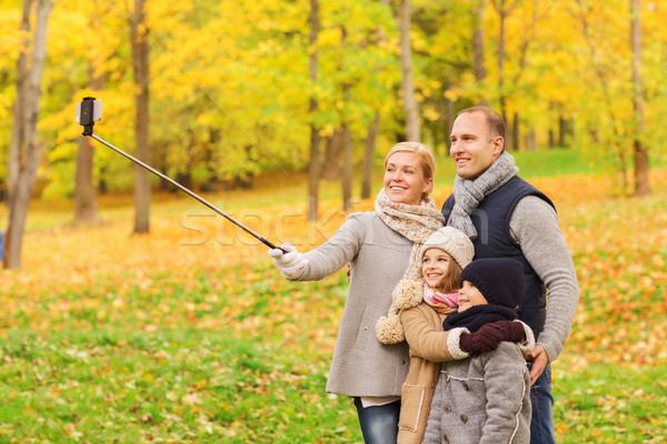 happy family with smartphone and monopod in park Stock photo © dolgachov