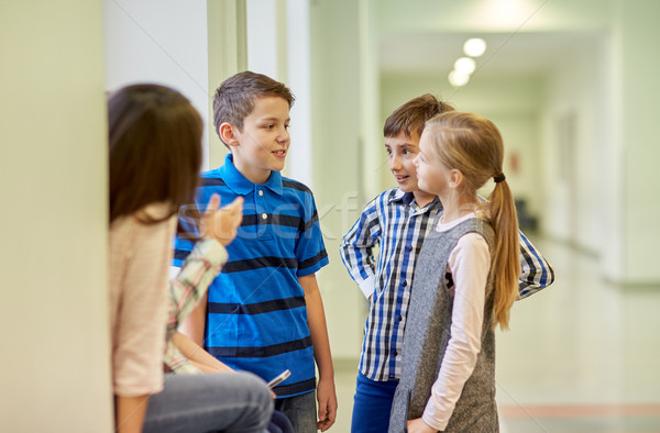 group of smiling school kids talking in corridor Stock photo © dolgachov