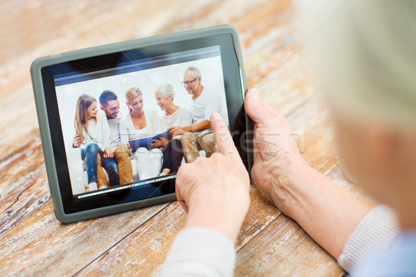 senior woman with family photo on tablet pc screen Stock photo © dolgachov