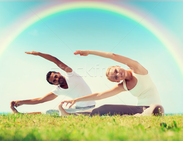 happy couple stretching and doing yoga exercises Stock photo © dolgachov