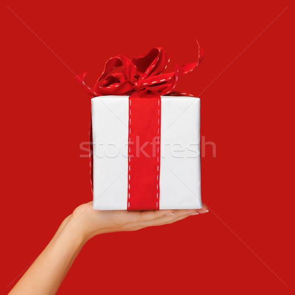 close up hand holding christmas gift box over red Stock photo © dolgachov