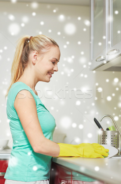 happy woman washing dishes at home kitchen Stock photo © dolgachov