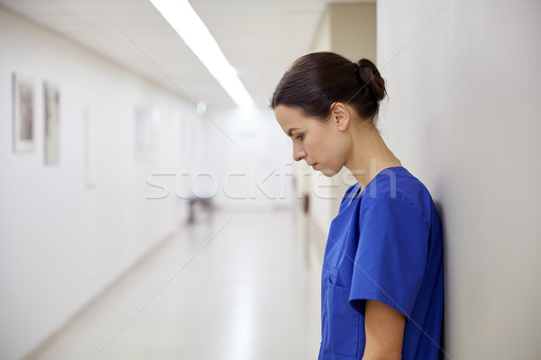 sad female nurse at hospital corridor Stock photo © dolgachov