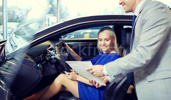 Stock photo: happy woman with car dealer in auto show or salon