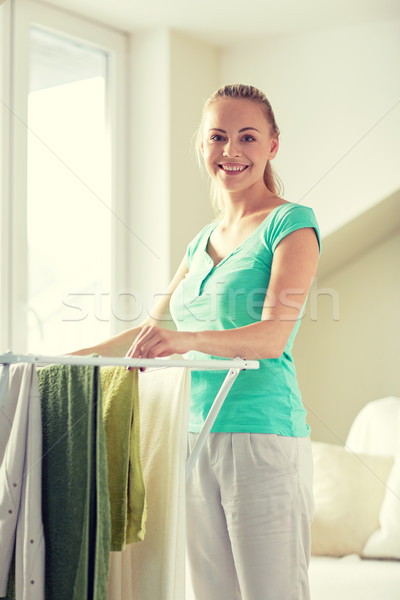 happy woman hanging clothes on dryer at home Stock photo © dolgachov