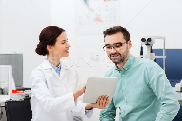 optician with tablet pc and patient at eye clinic Stock photo © dolgachov