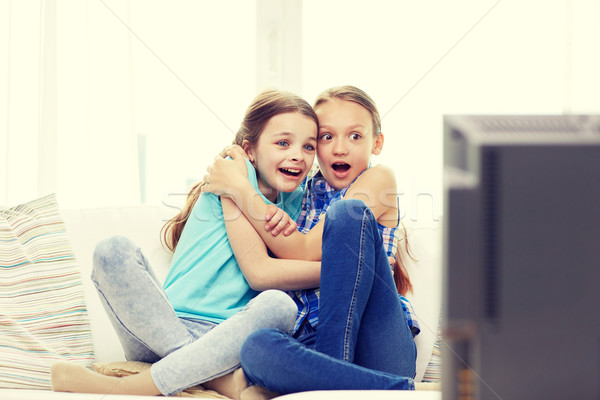 scared little girls watching horror on tv at home Stock photo © dolgachov