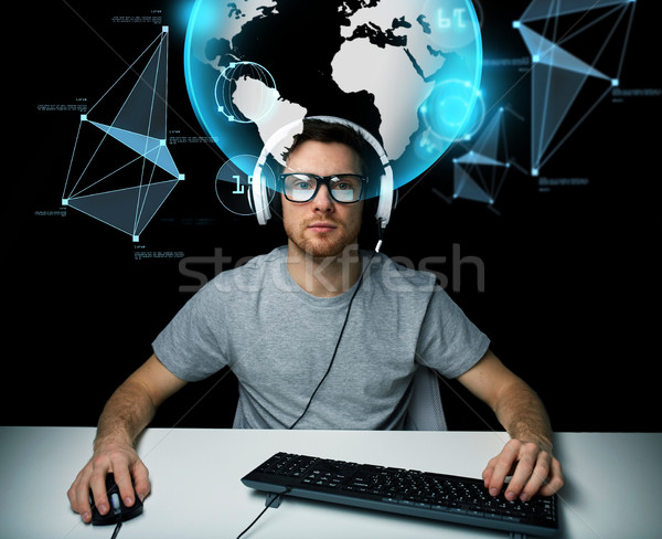 man in headset with computer over earth projection Stock photo © dolgachov