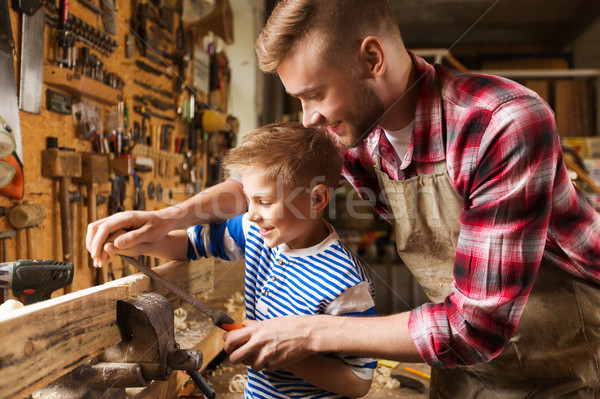 father and son with rasp working at workshop Stock photo © dolgachov