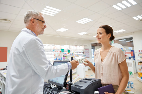 woman giving money to pharmacist at drugstore Stock photo © dolgachov