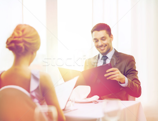 smiling young man looking at menu at restaurant Stock photo © dolgachov