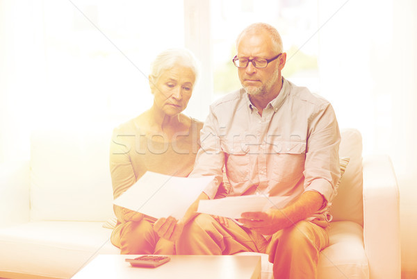 senior couple with papers and calculator at home Stock photo © dolgachov