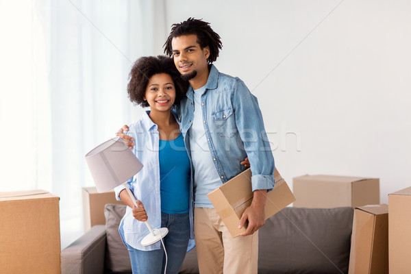 happy couple with stuff moving to new home Stock photo © dolgachov