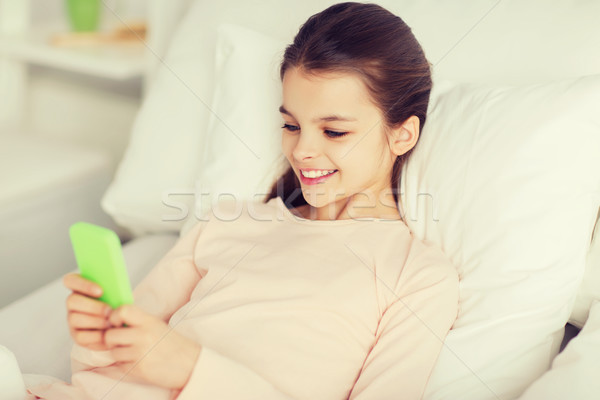 Mädchen glücklich Bett Smartphone home Menschen Kinder Stock foto © dolgachov