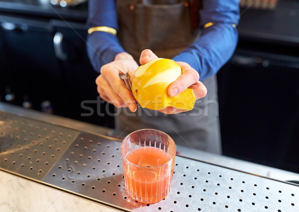 bartender removing peel from lime at bar Stock photo © dolgachov