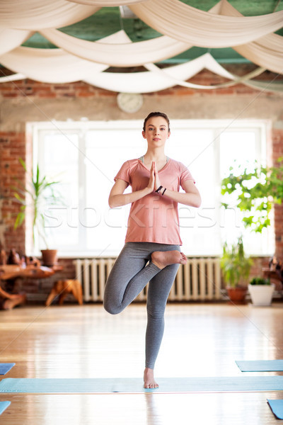 young woman doing yoga tree pose at studio Stock photo © dolgachov