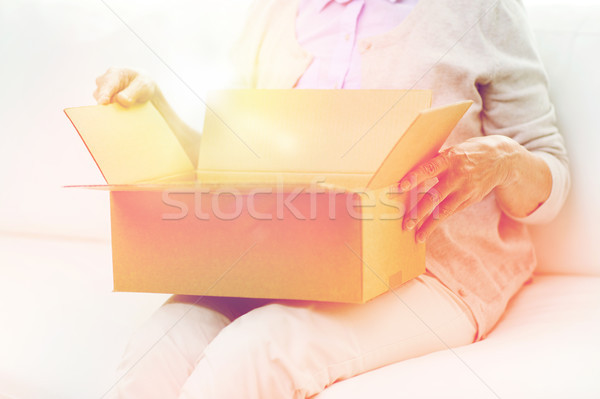 Stock photo: close up of senior woman with parcel box at home