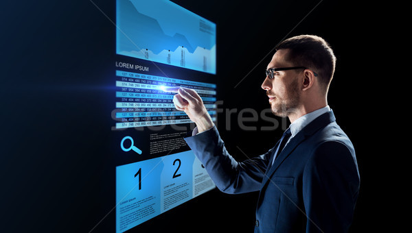Stock photo: businessman with stock charts on virtual screens