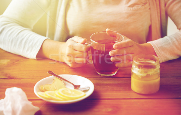 close up of woman adding lemon to tea cup Stock photo © dolgachov