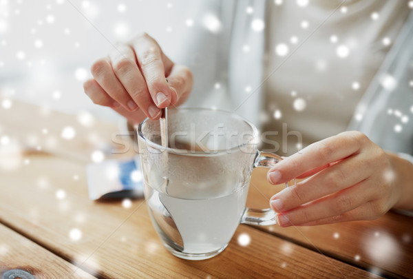 ill woman stirring medication in cup with spoon Stock photo © dolgachov